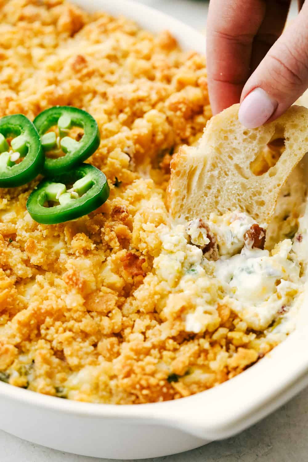 Zanurzanie chleba w kremowym dipie jalapeno.