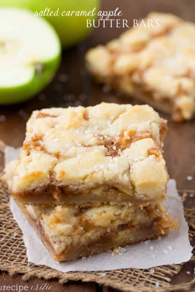 Salad caramel apple butter bars stacked on top of each other with parchment paper underneath. 