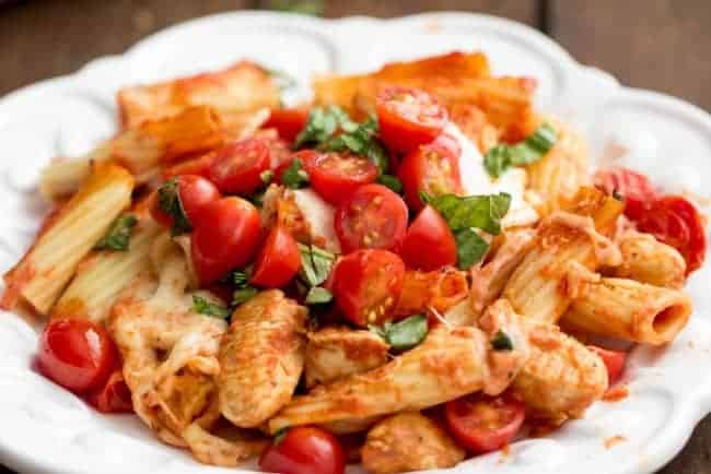 Chicken caprese pasta casserole in a white casserole dish. 