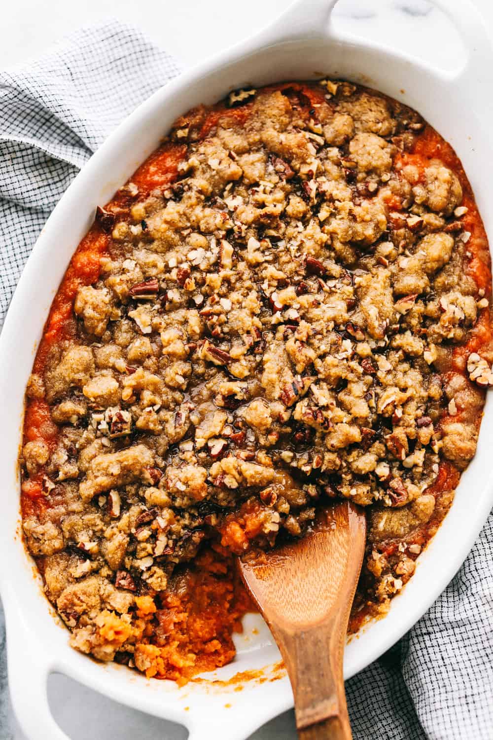 A sweet potato casserole in a white serving dish.