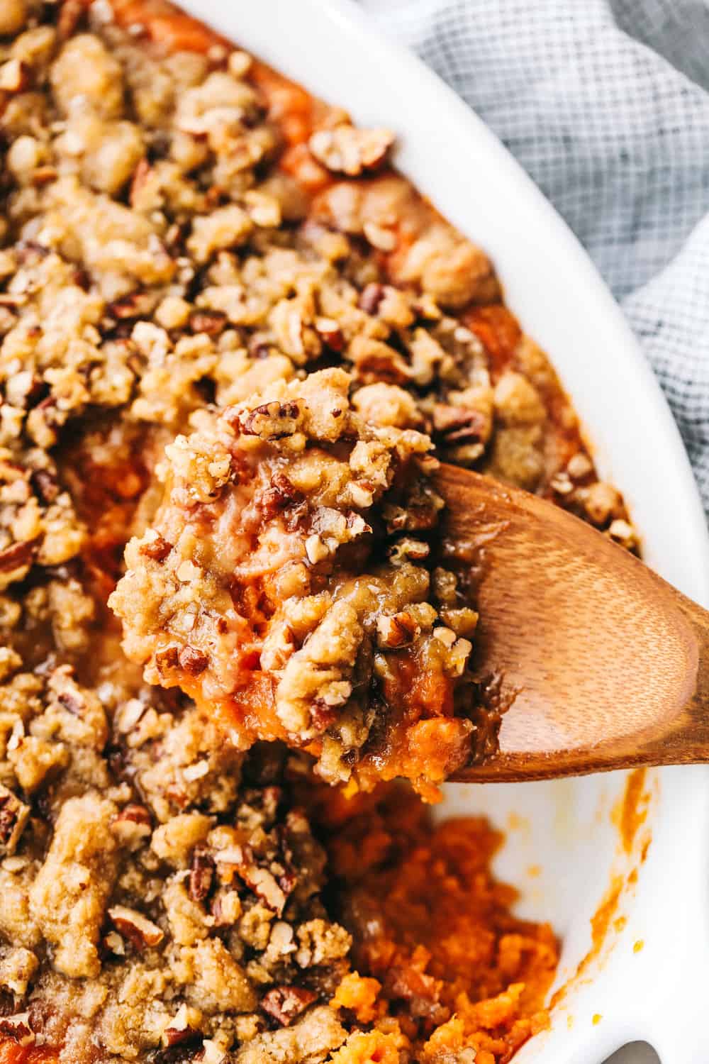 baked sweet potato casserole with a wooden spoon 