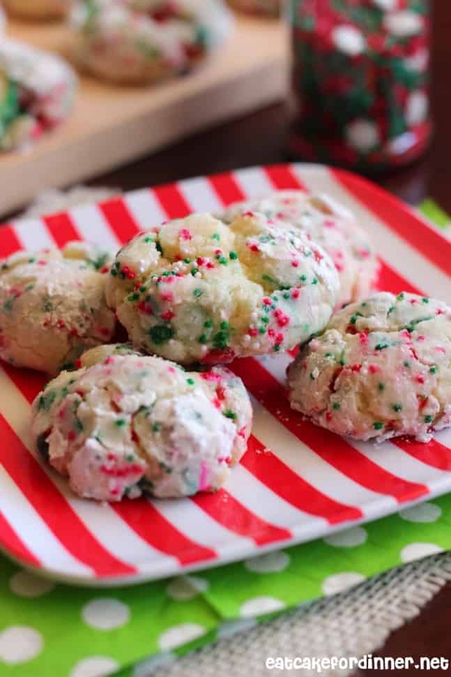 Christmas Gooey Butter Cookies on a white and red plate. Napkins with green with white dots under it. 