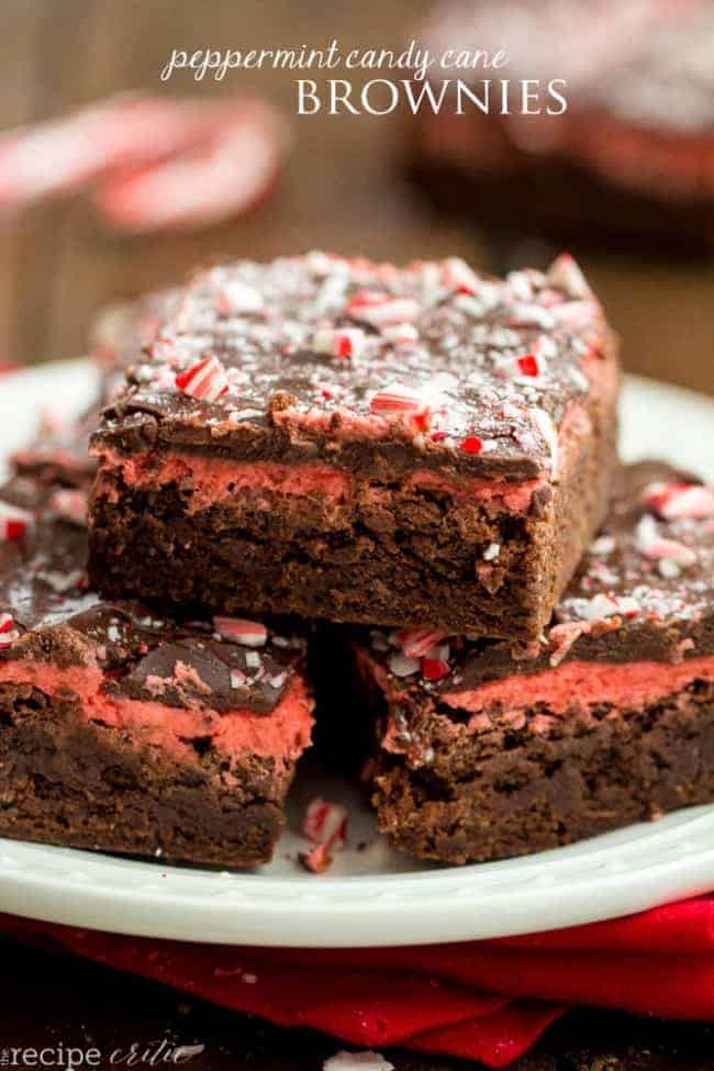 Peppermint candy cane brownies stacked on top of each other on a white plate. 