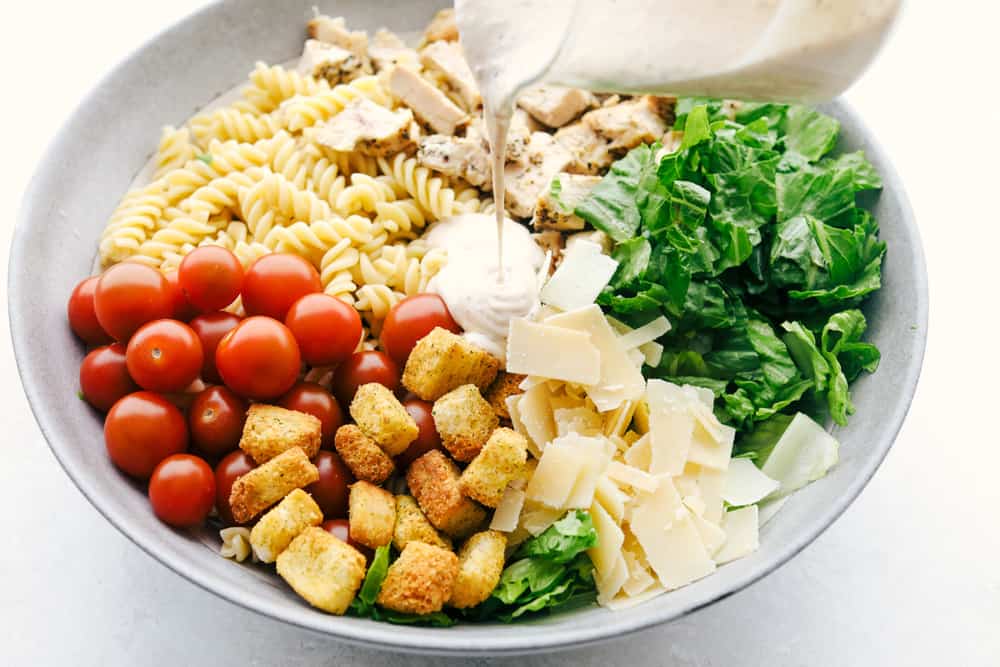 Pouring the dressing on the salad. 