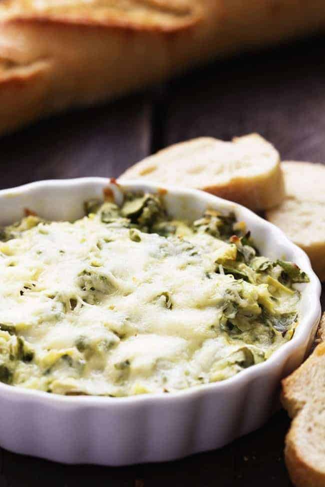 Spinach artichoke dip in a shallow white bowl.