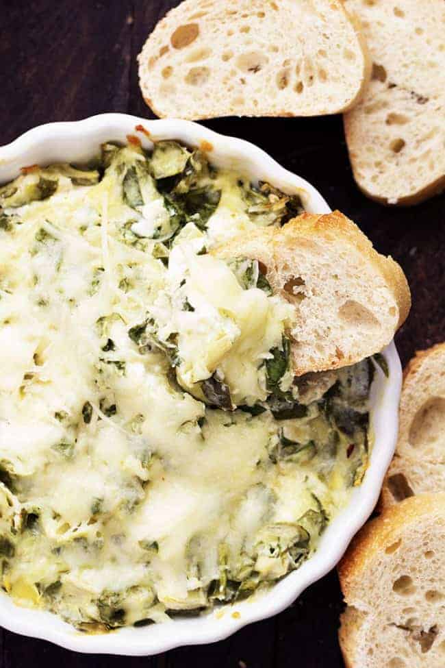 Spinach artichoke dip areal view with bread pieces.