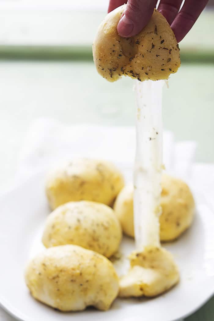 Garlic Parmesan Cheese Bomb being pulled apart to show the gooey cheese.