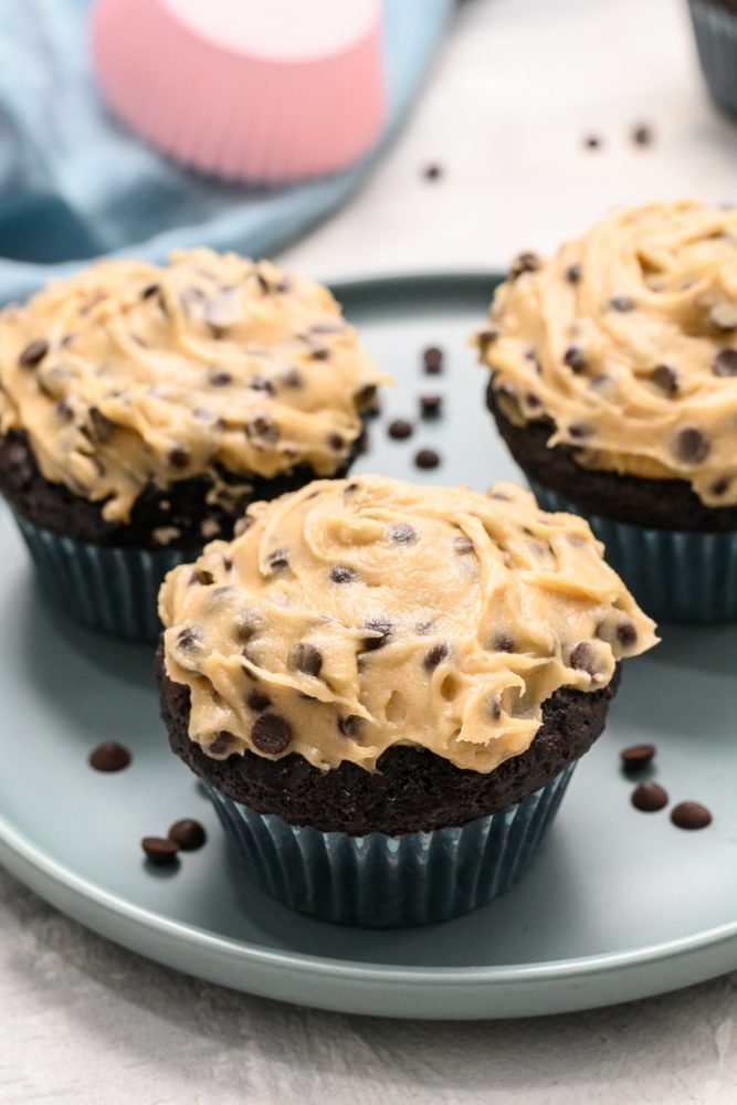 Chocolate cupcakes with cookie dough frosting on a plate.