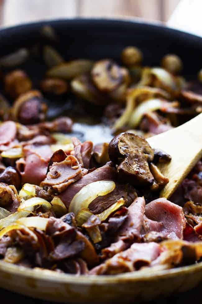 philly cheesesteak cooking in a pan.