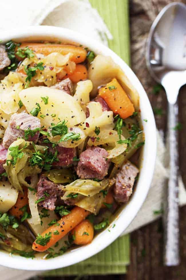 Corned beef cabbage stew in a white bowl.