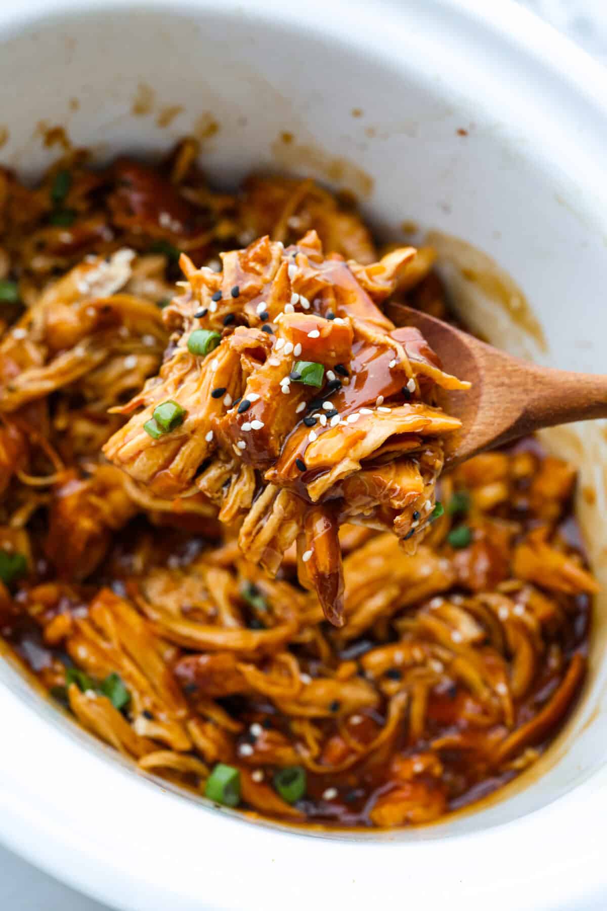 Close up shot of a scoop of slow cooker honey teriyaki chicken. 