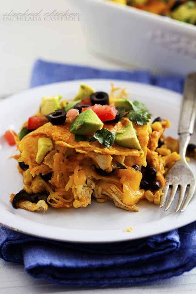 stacked chicken enchilada casserole on a white plate.