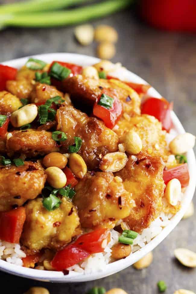 Baked Kung Pao chicken over white rice in a bowl. 