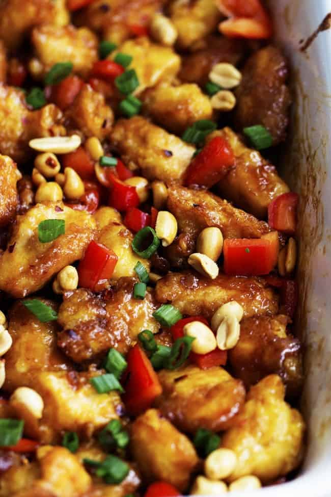 Baked Kung Pao Chicken in a baking pan garnished with peanuts.