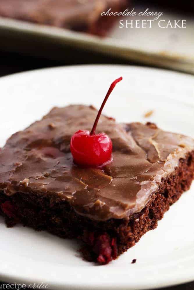 chocolate cherry sheet cake square with a cherry on top on a white plate.