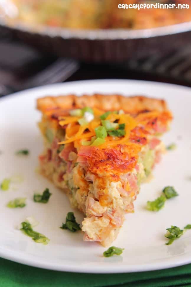Finished photo of a serving of ham and Broccoli Quiche on a white plate.