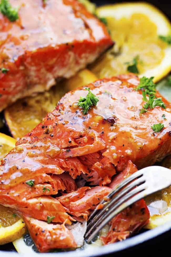 Pulling apart grilled citrus salmon with a fork close up.