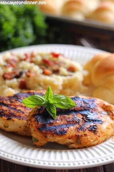 grilled basil rub chicken on a white plate.