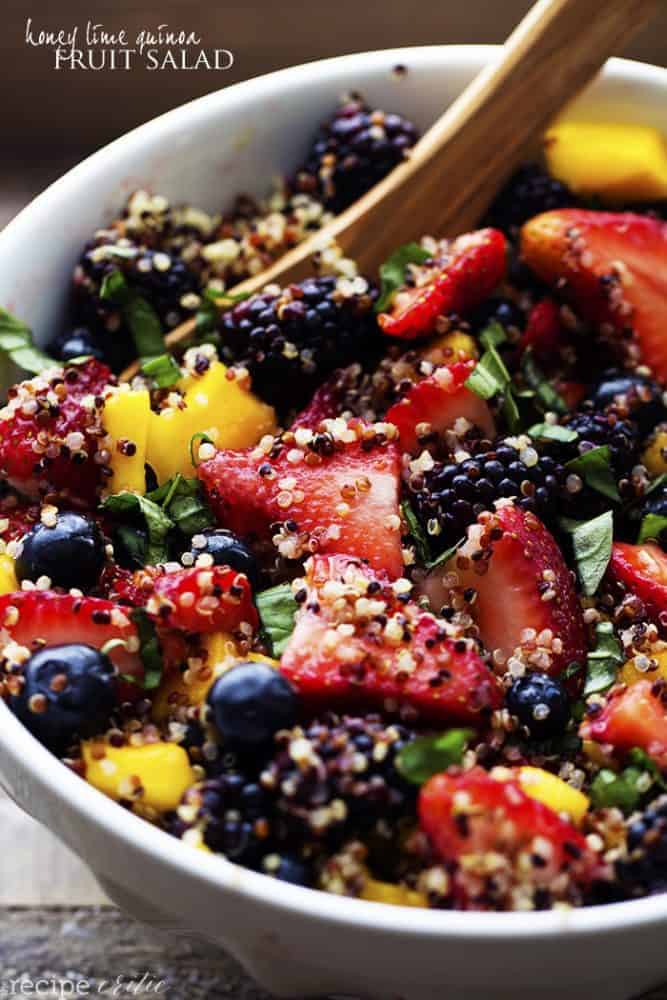 honey lime quinoa fruit salad in a white bowl.
