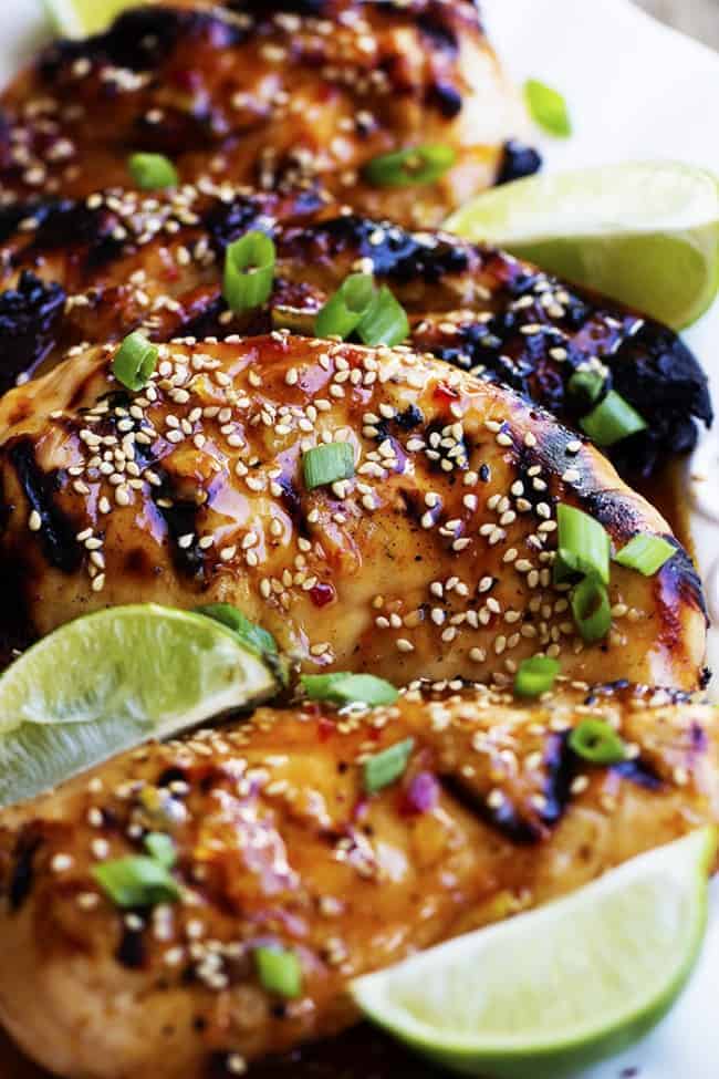 sweet chili lime chicken close up with lime and sesame seed garnish.