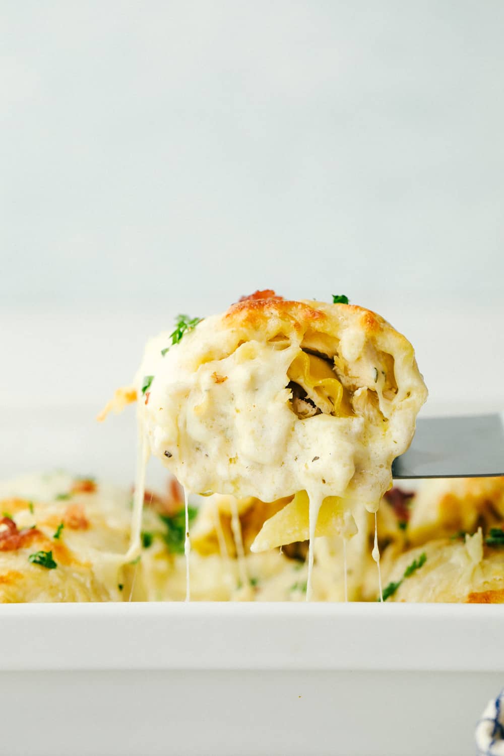 Scooping out a lasagna roll up out of the pan. 