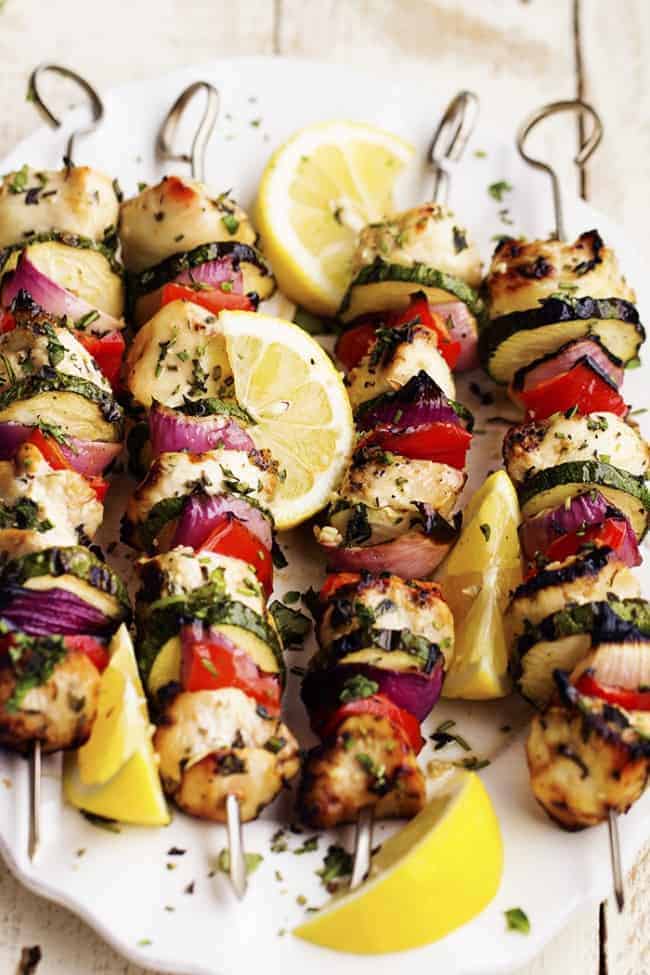 lemon herb chicken skewers on a white plate.