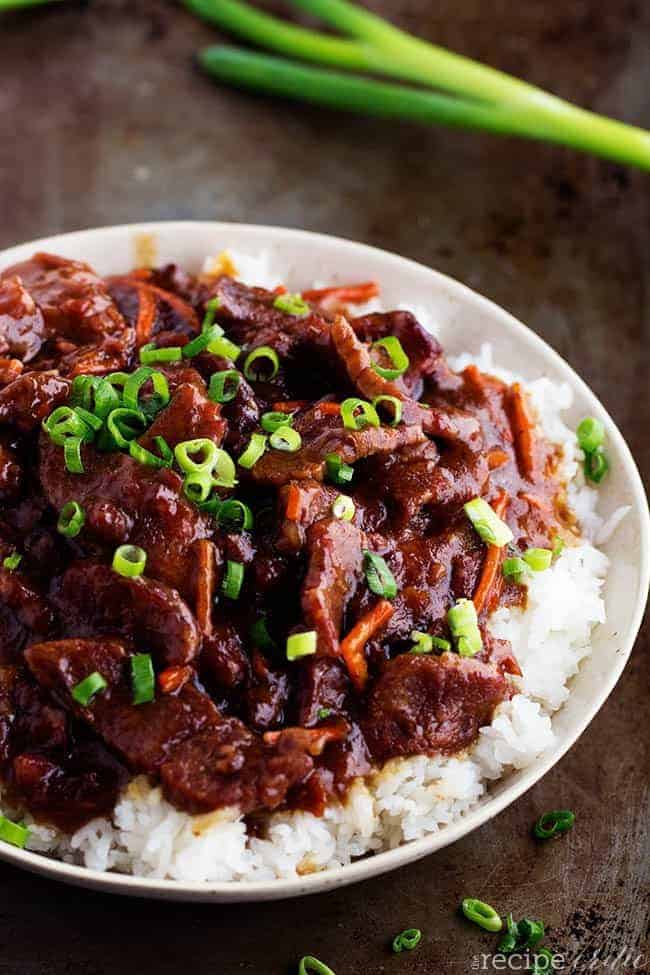 Slow cooker mongolian beef on rice and a white plate.