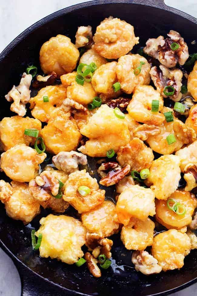 Areal view of honey walnut shrimp in a black cast iron skillet.
