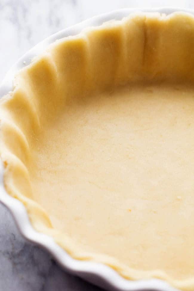 Pie crust dough pushed into a pie dish.