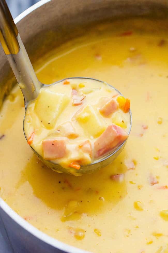 Ham and Cheddar Potato Soup being scooped up in a ladle.