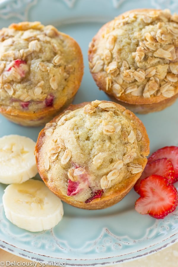 Strawberry Banana Oat Muffins on plate with strawberry and banana.