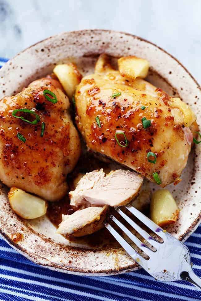 Chicken on plate with garlic and onion.
