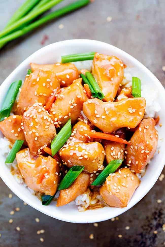 Mongolian chicken over white rice in a white bowl.