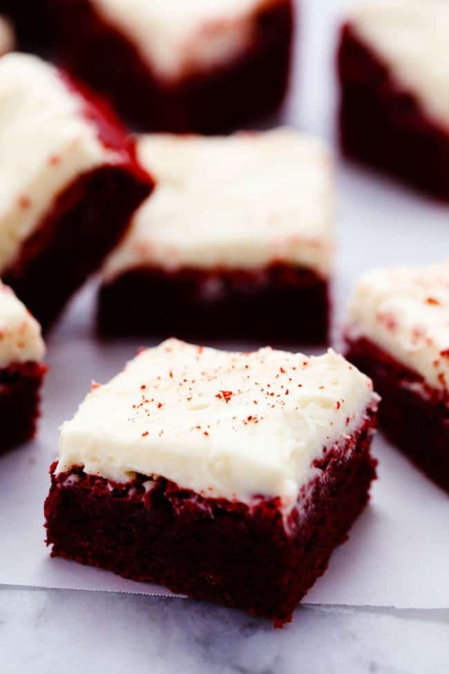 Red velvet brownies cut into pieces laying on apartment paper