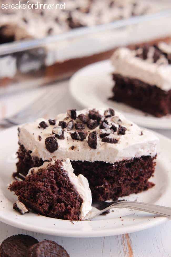Skinny Cookies n Cream Cake mit einer Gabel auf einem weißen Teller, auf dem ein Stück Kuchen liegt. 
