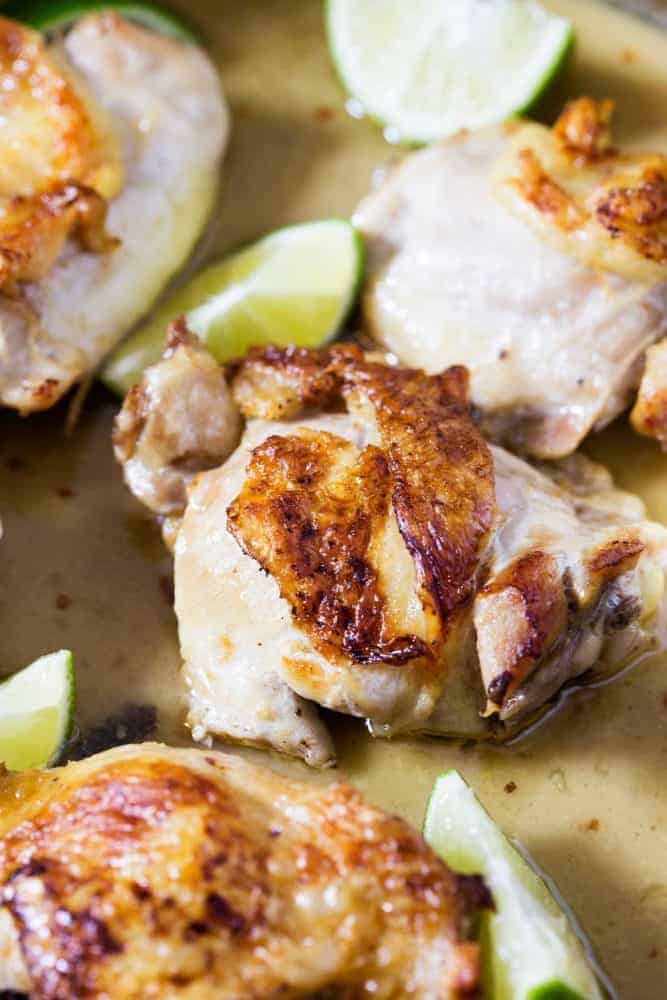 Coconut lime skillet chicken with fresh cut limes on the side.