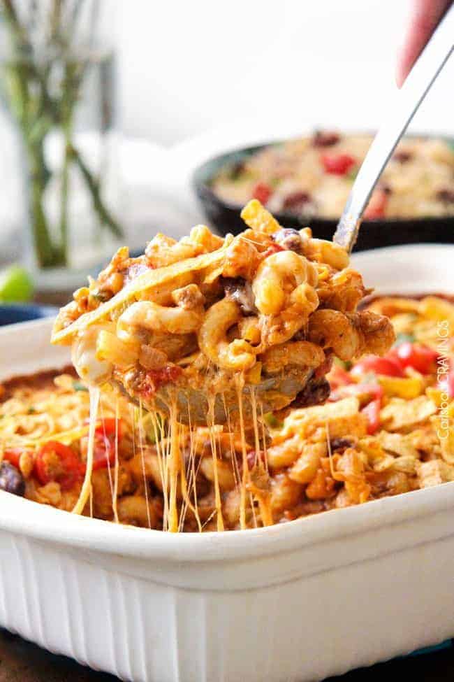 Taco Chili Pasta Bake in a white casserole dish with a spoon removing some. 