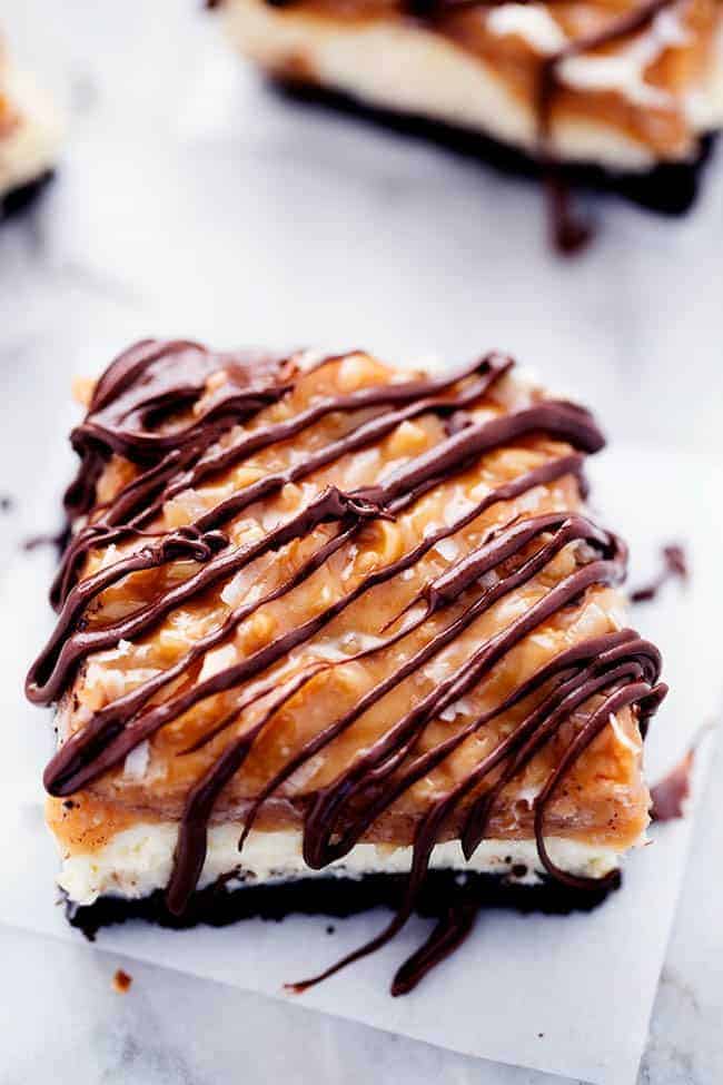 Up close photo of Samoa cheesecake bar on parchment paper.