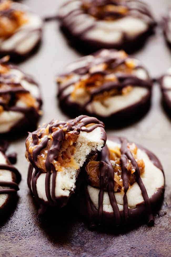 Nahaufnahme von Schokoladen-Fingerabdruck-Samoa-Keksen, von denen einer angebissen wurde.