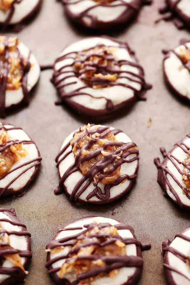 Close up photo of Samoa thumbprint cookies with chocolate drizzled on top.