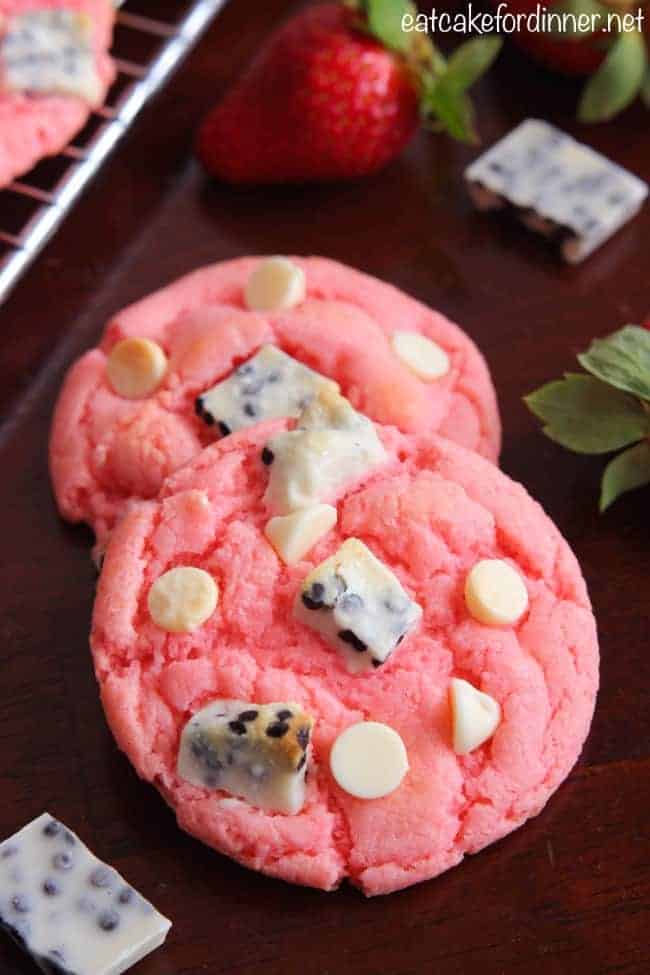 Strawberry Cookies 'n Cream Cookies on table with fresh strawberries in background.