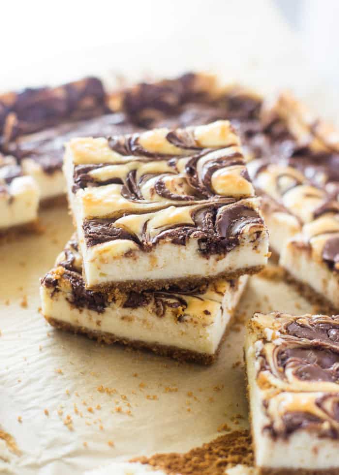 Nutella Swirl Cheesecake Bars sliced into two inch squares and stacked on top of one another. 