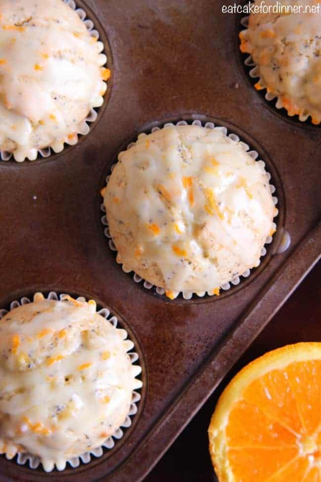 Overhead photo of Banana Poppy Seed Muffins with an Orange Glaze in a muffin tin. 