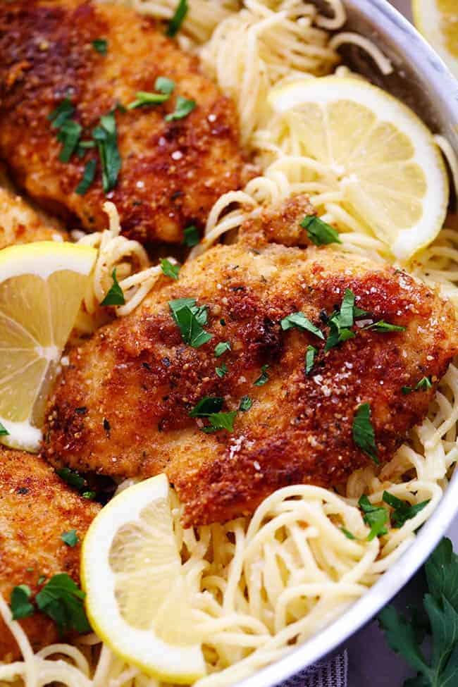 Close up photo of Crispy Parmesan Chicken with Creamy Lemon Garlic Pasta in a metal frying pan. 