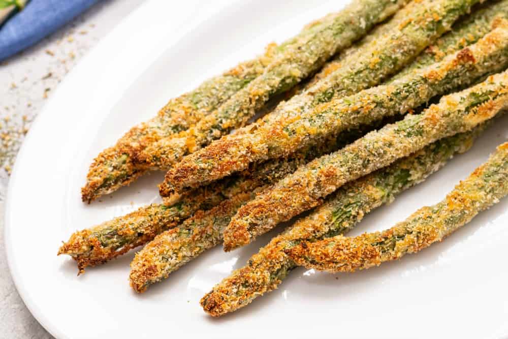 Close up photo of Parmesan Herb Asparagus Fries on a white plate. 