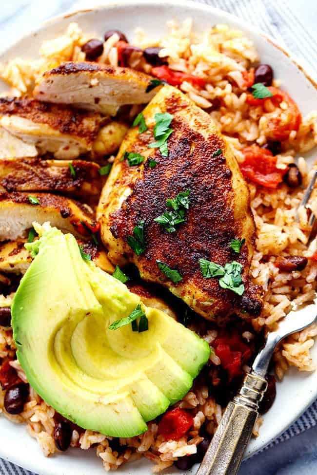 One Pan Southwest Blackened Cajun Chicken with Rice with fresh cut avocado on a white plate. 