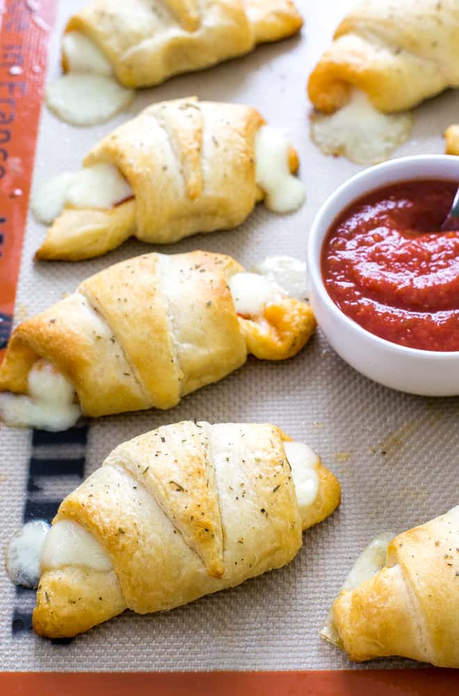 Cresent rolls in a row with sauce.
