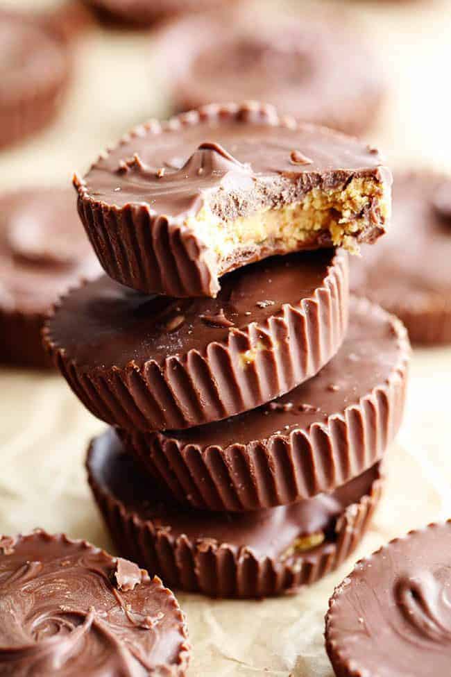 Homemade Reese's peanut butter cups stacked on top of one another. One with the bite taken out of it.