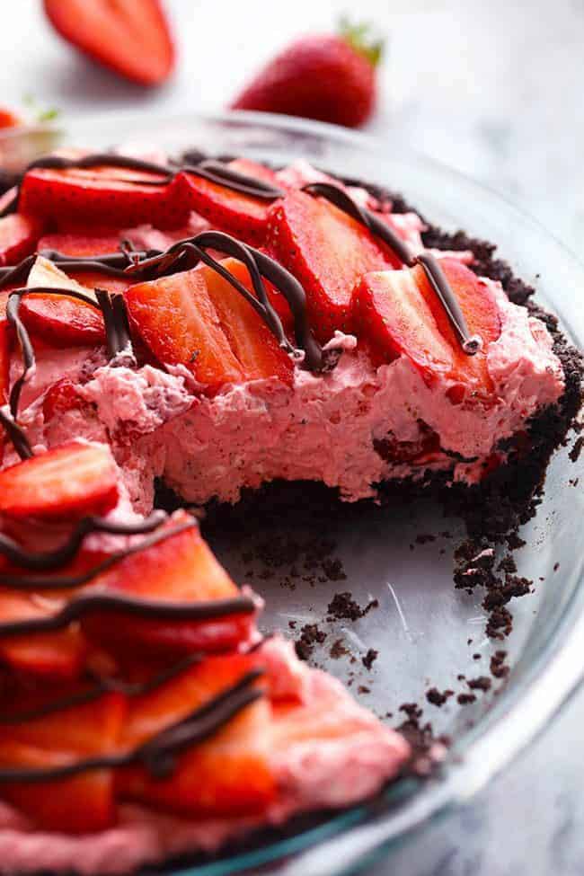 No Bake Chocolate Strawberries and Cream Pie with a slice removed in a clear pie pan. 