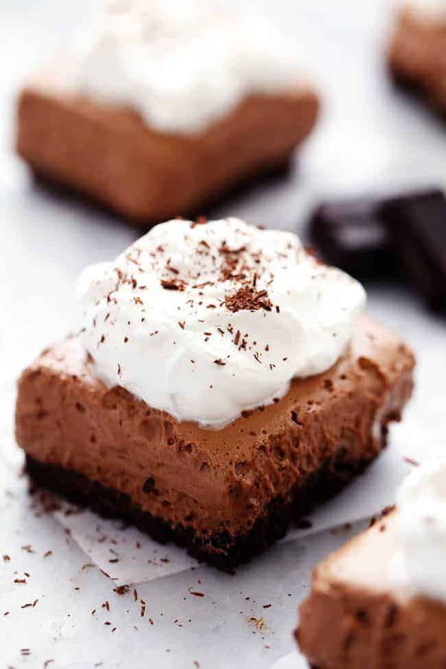 French Silk Pie Bar with whipped topping on parchment paper. 